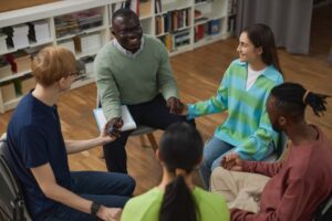 People in support group circle holding hands